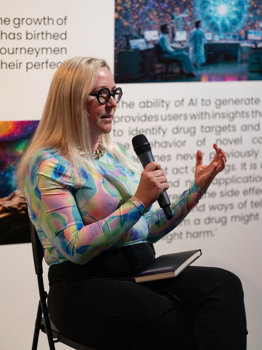Photo of the artist Andrea Khôra speaking into a microphone